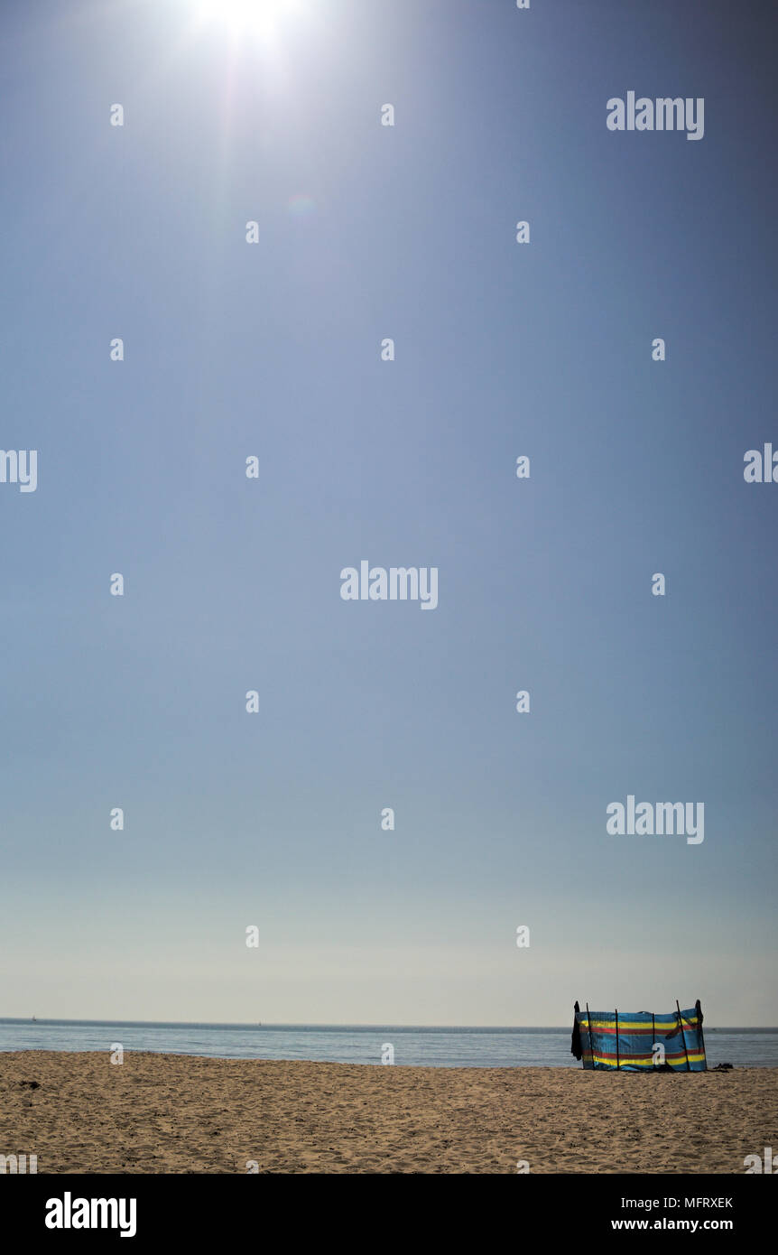 Eine leere Sandstrand Szene an einem sonnigen Tag mit blauem Himmel und Horizont mit einem farbigen wind Bruch mit kopieren. Der Strand ist Bournemouth in England. Stockfoto