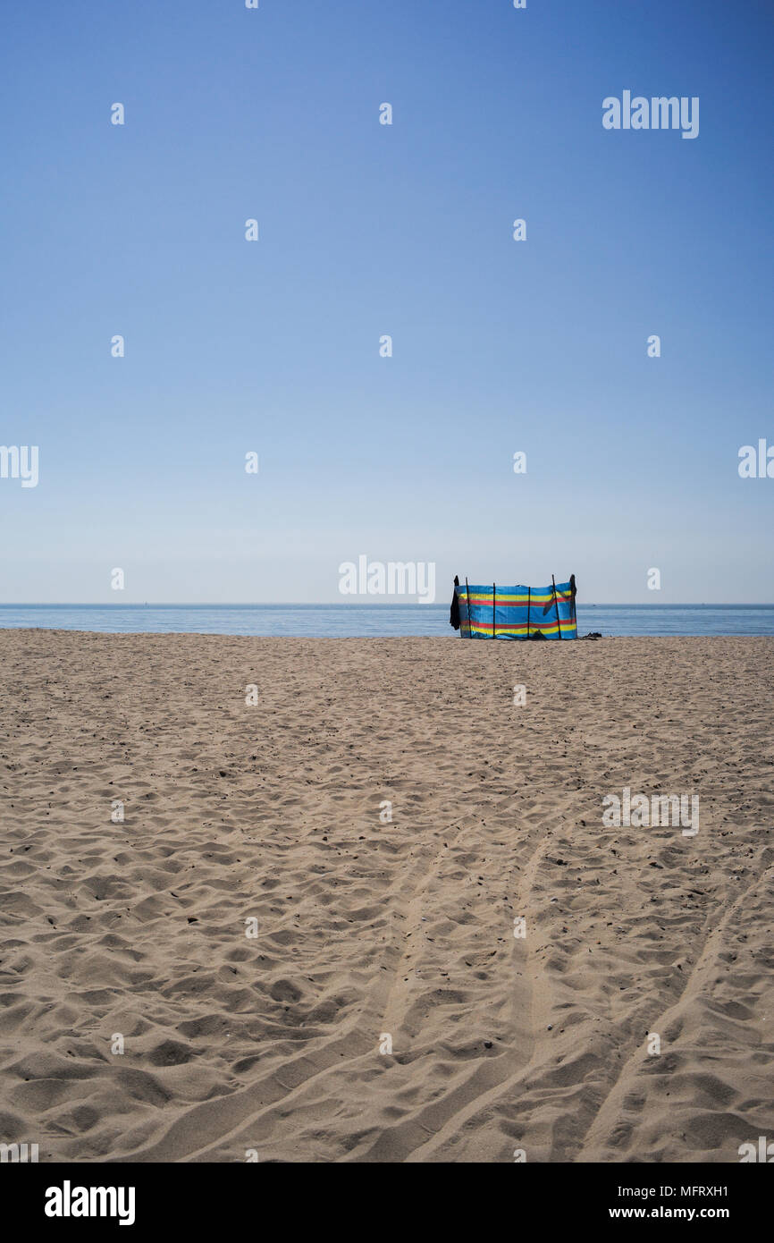 Eine leere Sandstrand Szene an einem sonnigen Tag mit blauem Himmel und Horizont mit einem farbigen wind Bruch mit kopieren. Der Strand ist Bournemouth in England. Stockfoto