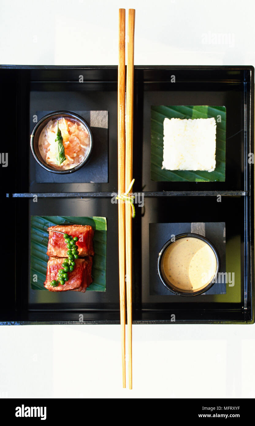 Sushi am schwarzen, quadratischen Teller, Essstäbchen, Detail, japanisches Essen, Fisch, Stockfoto