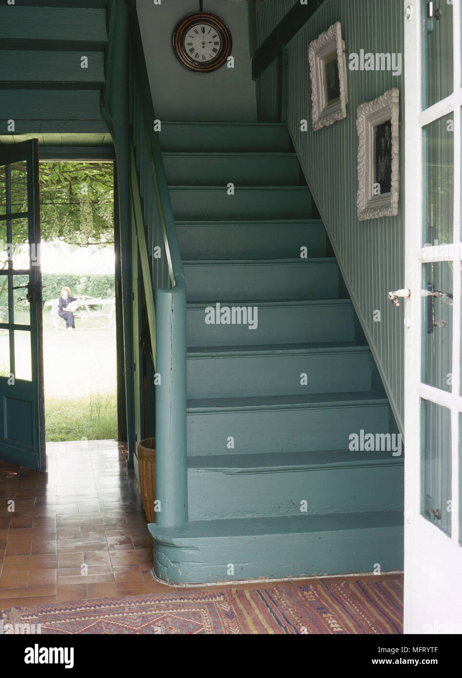 Blick durch die offene Tür zu grün lackiert Treppe im traditionellen Stil Flur Stockfoto