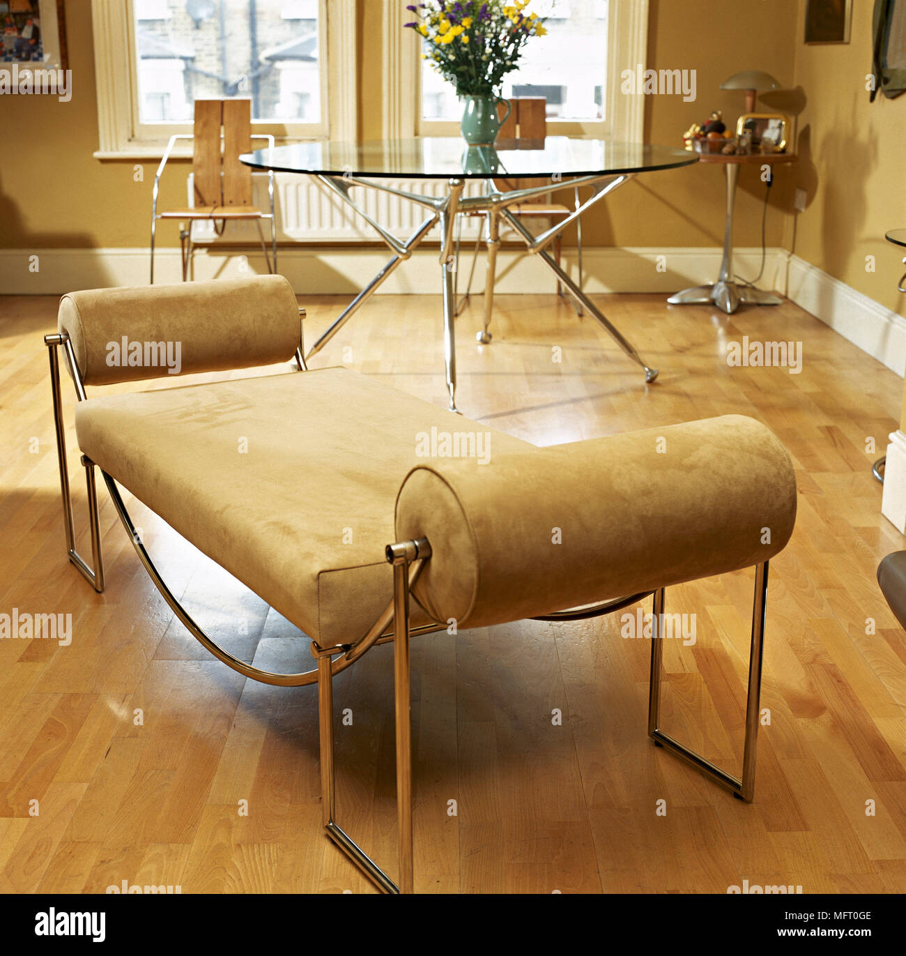 Leder Und Metall Chaiselongue Im Speiseraum Mit Holzfussboden Runder Esstisch Aus Glas Und Sonnigen Fenster Stockfotografie Alamy