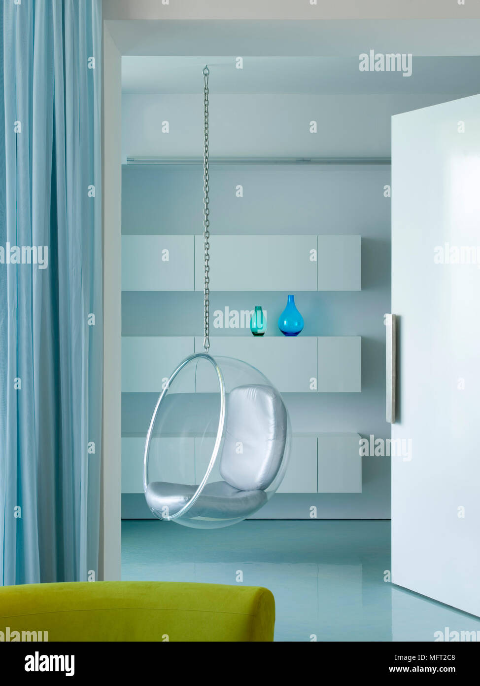 Ein Modernes Retro Stil Wohnzimmer Ein Eero Aarnio Bubble Chair Von Der Decke Abgehangt Weisse Regale Stockfotografie Alamy
