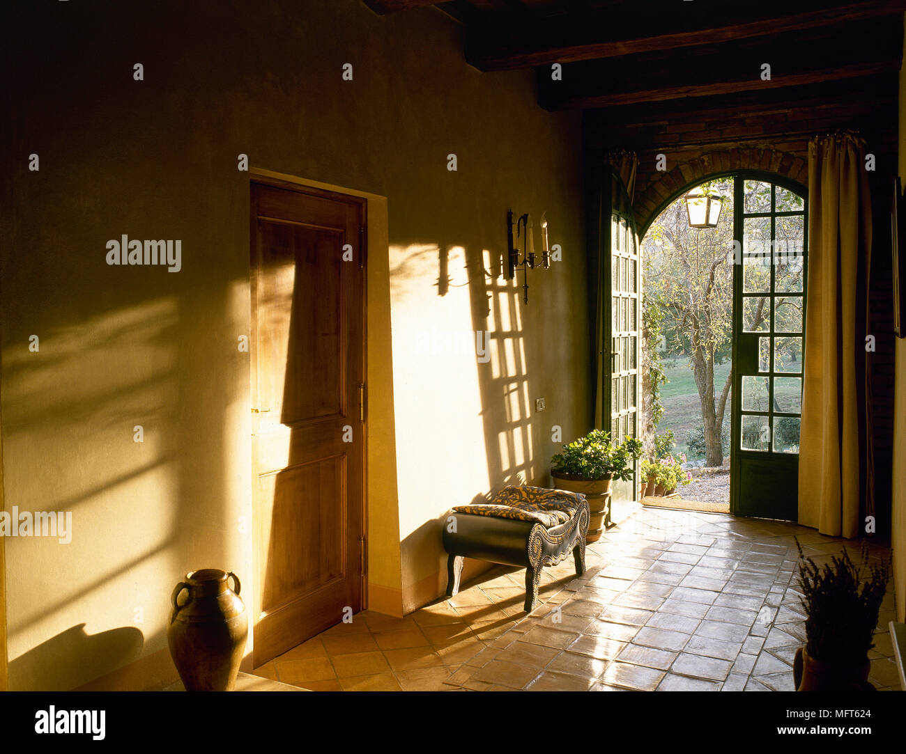 Landhausstil Diele mit offener Tür und Steinboden, Stockfoto