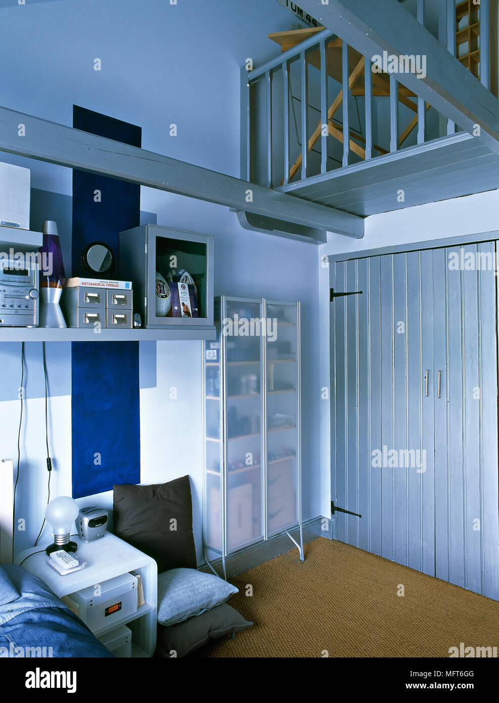 Moderne, blau Schlafzimmer mit offene Regale, Stahlträger, getäfelte  Schranktüren und ein Loft Stockfotografie - Alamy