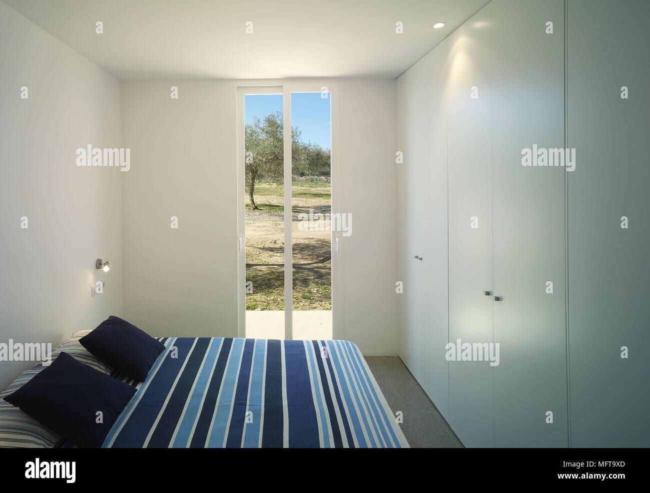 Doppelbett mit blau gestreiften in modernem minimalistischen Schlafzimmer Stockfoto