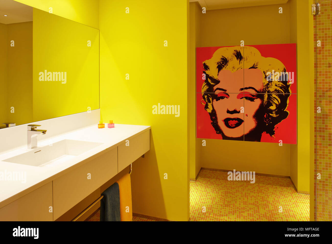 Spiegel über dem Waschbecken im Regal in der zeitgenössischen gelb Bad mit Andy Warhol Marilyn Monroe Siebdruck auf Wand Stockfoto