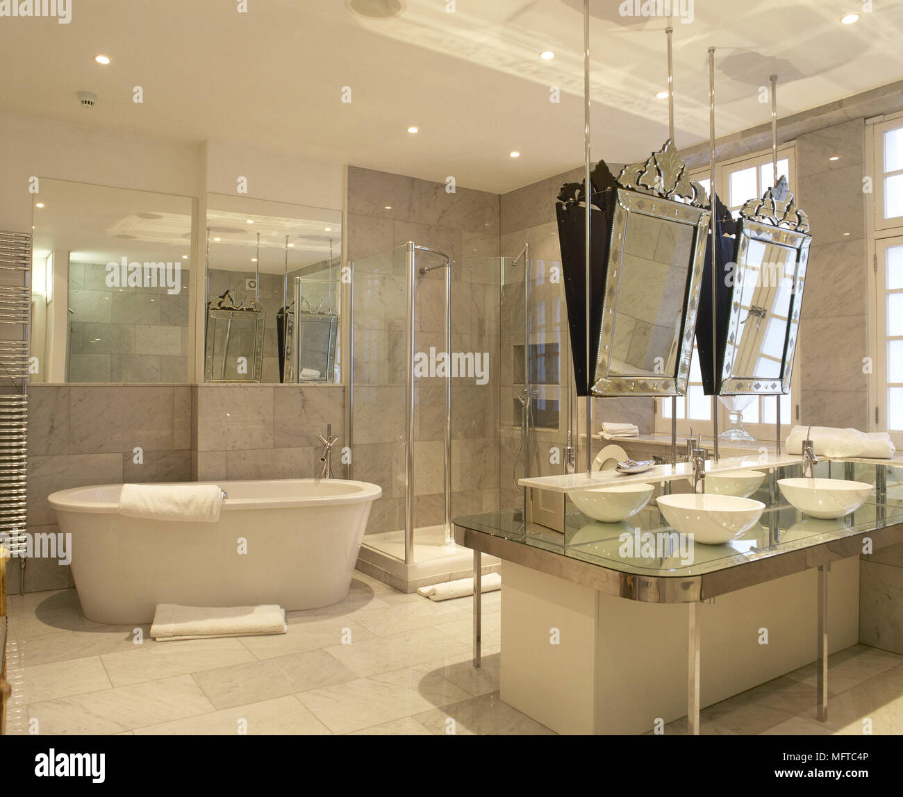 Geräumige, gefliestes Badezimmer mit zwei Waschbecken im Zentrum der Insel,  eine freistehende Badewanne, und verzierten Spiegel Stockfotografie - Alamy