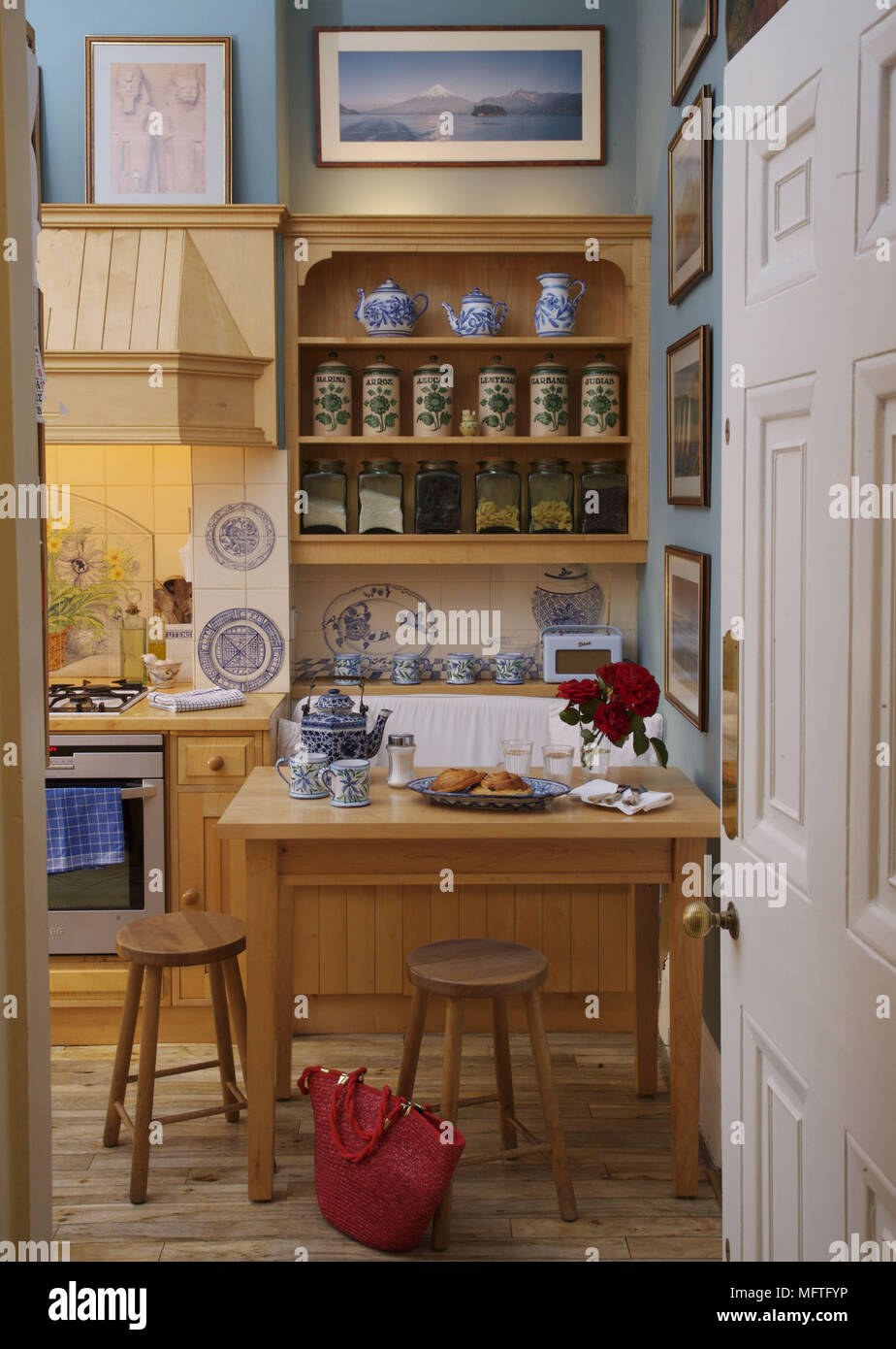 Blick durch die offene Tür zum Frühstück Tisch und Stühle in blau Küche Stockfoto