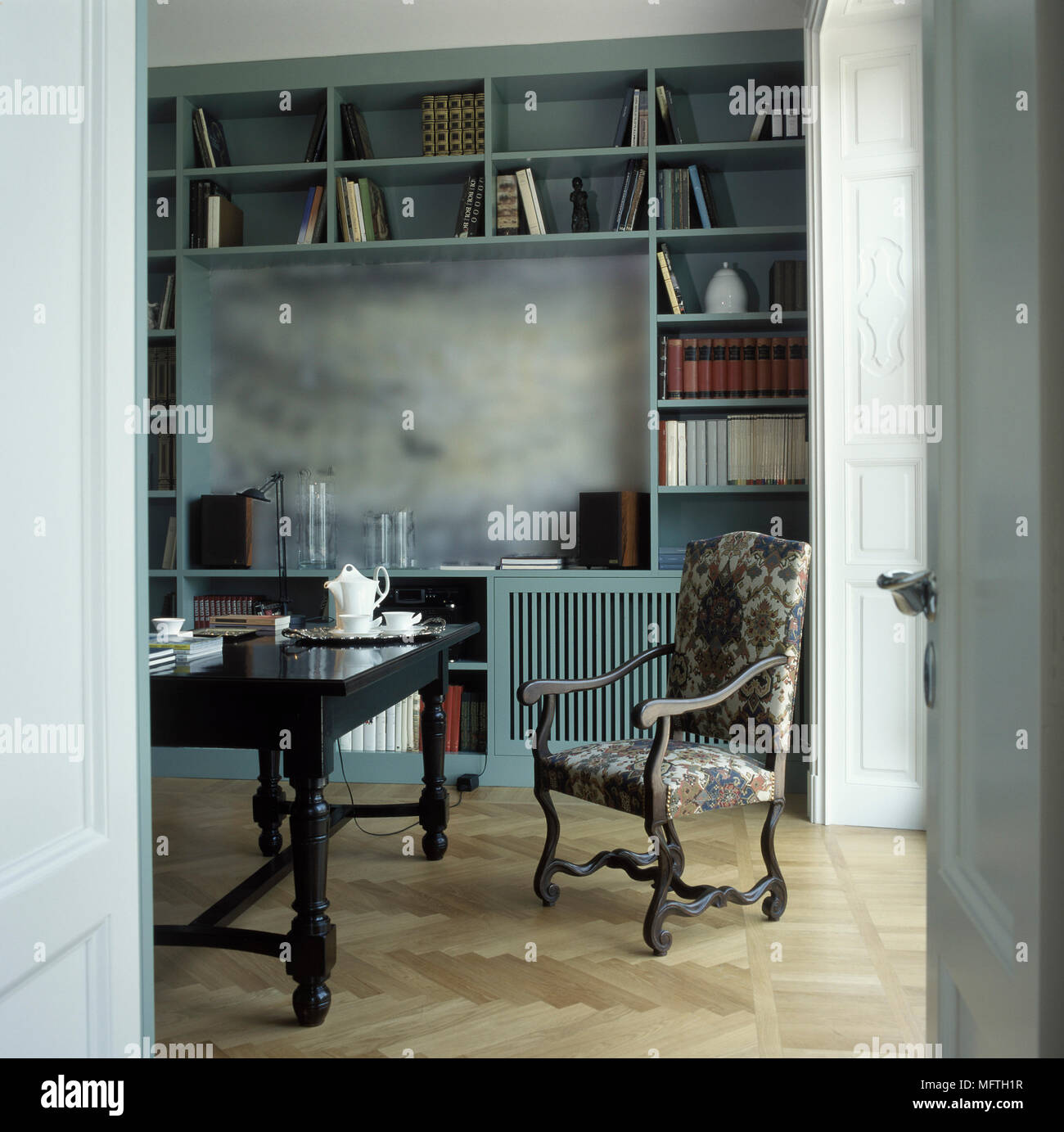 Esszimmer durch offene Türen mit gepolstertem Sessel gesehen Stockfoto