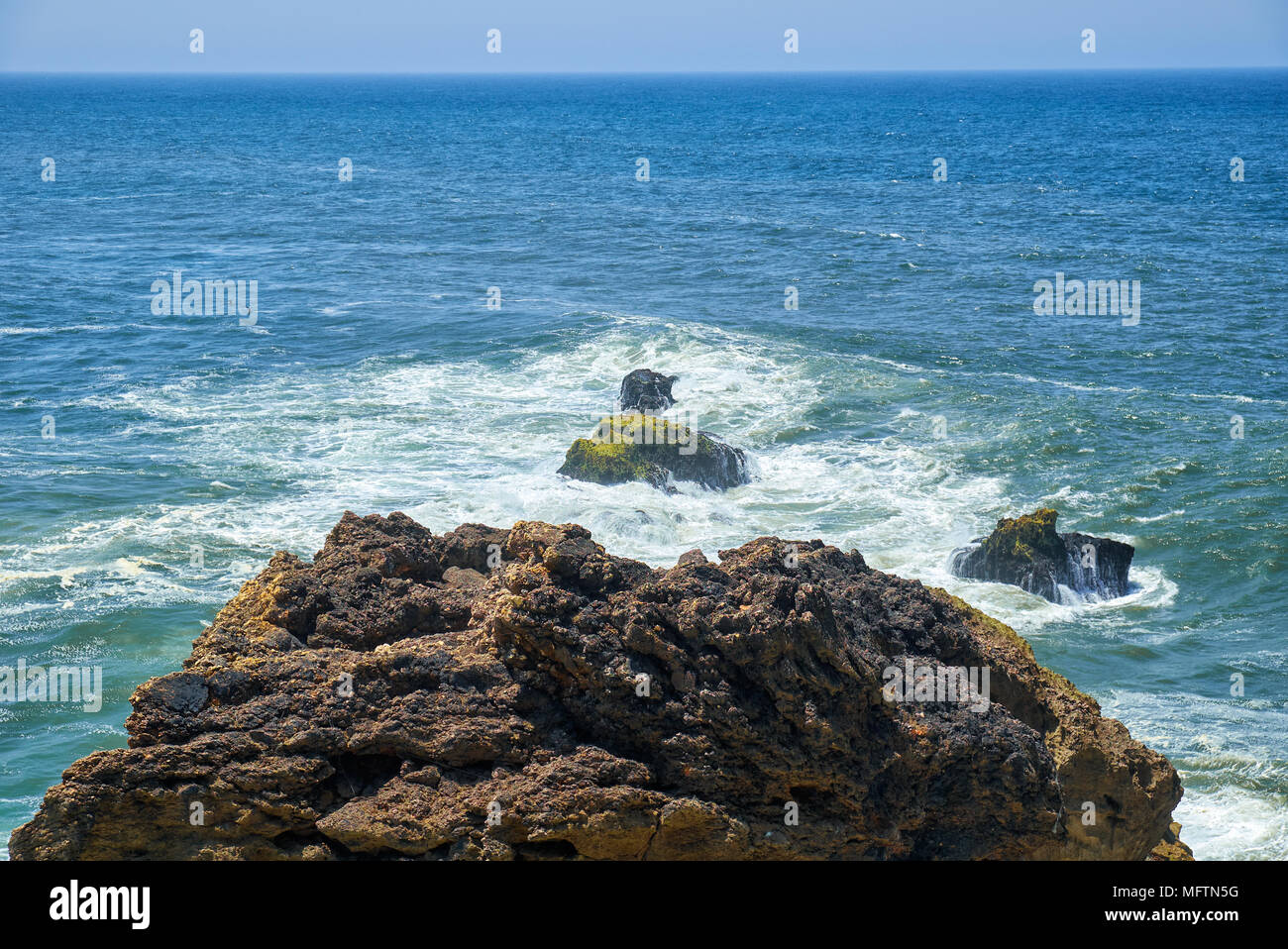 Felsen und Wellen der Brandung in den Ozean in der Nähe von Farol De Nazare Küste, in der Nähe der portugiesischen Stadt Nazare, Portugal Stockfoto