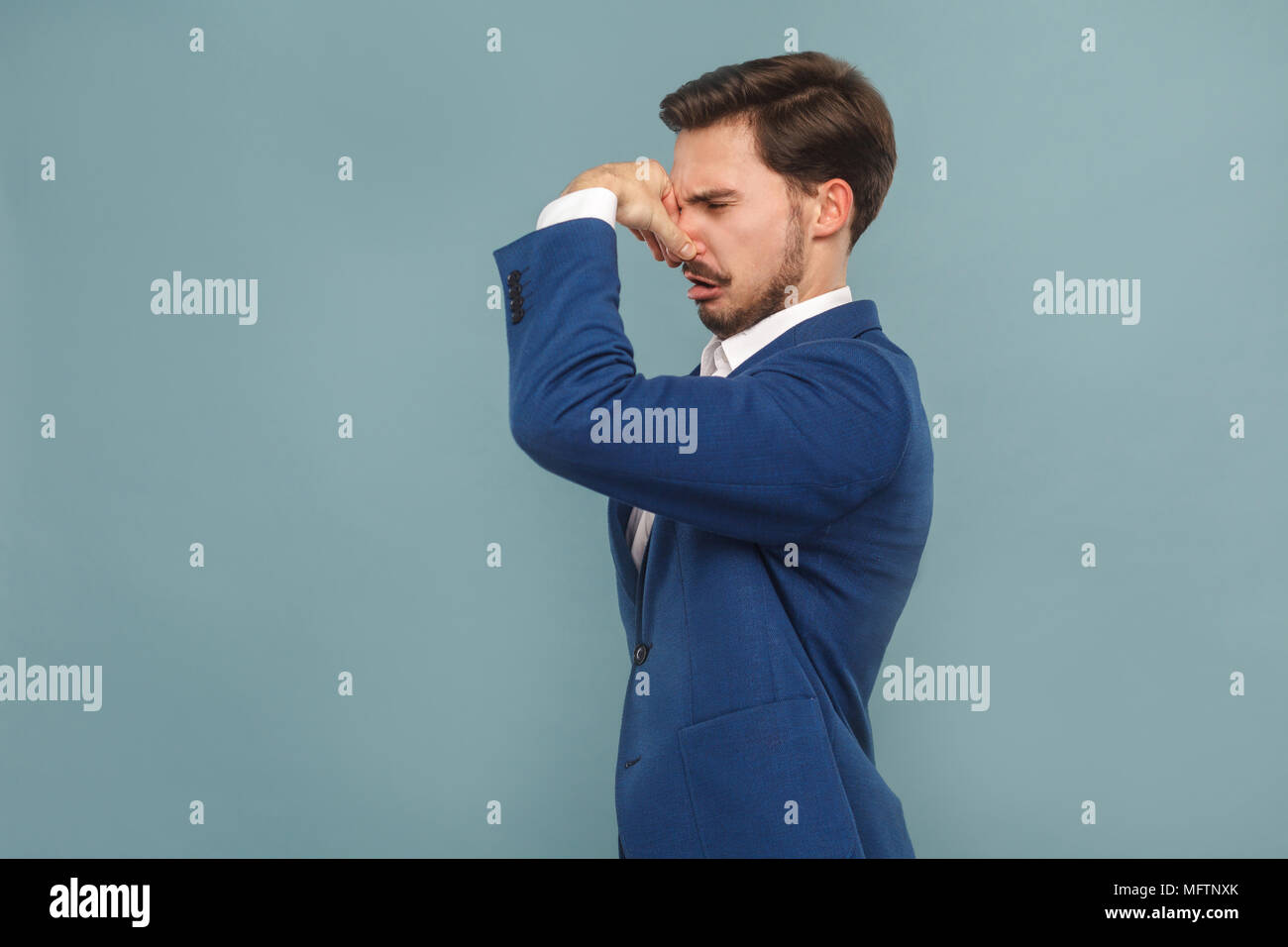 Fu, was schlecht riechen? Unglückliche Menschen geschlossen Nase Hand. Business Personen Konzept, reich und der Erfolg. Innen-, Studio shot auf hellblauem Hintergrund Stockfoto