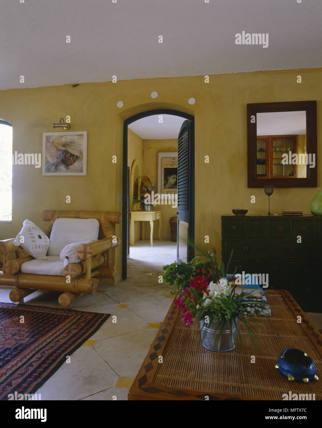 Wohnbereich mit Sessel und Couchtisch mit offener Tür zum nächsten Raum Stockfoto