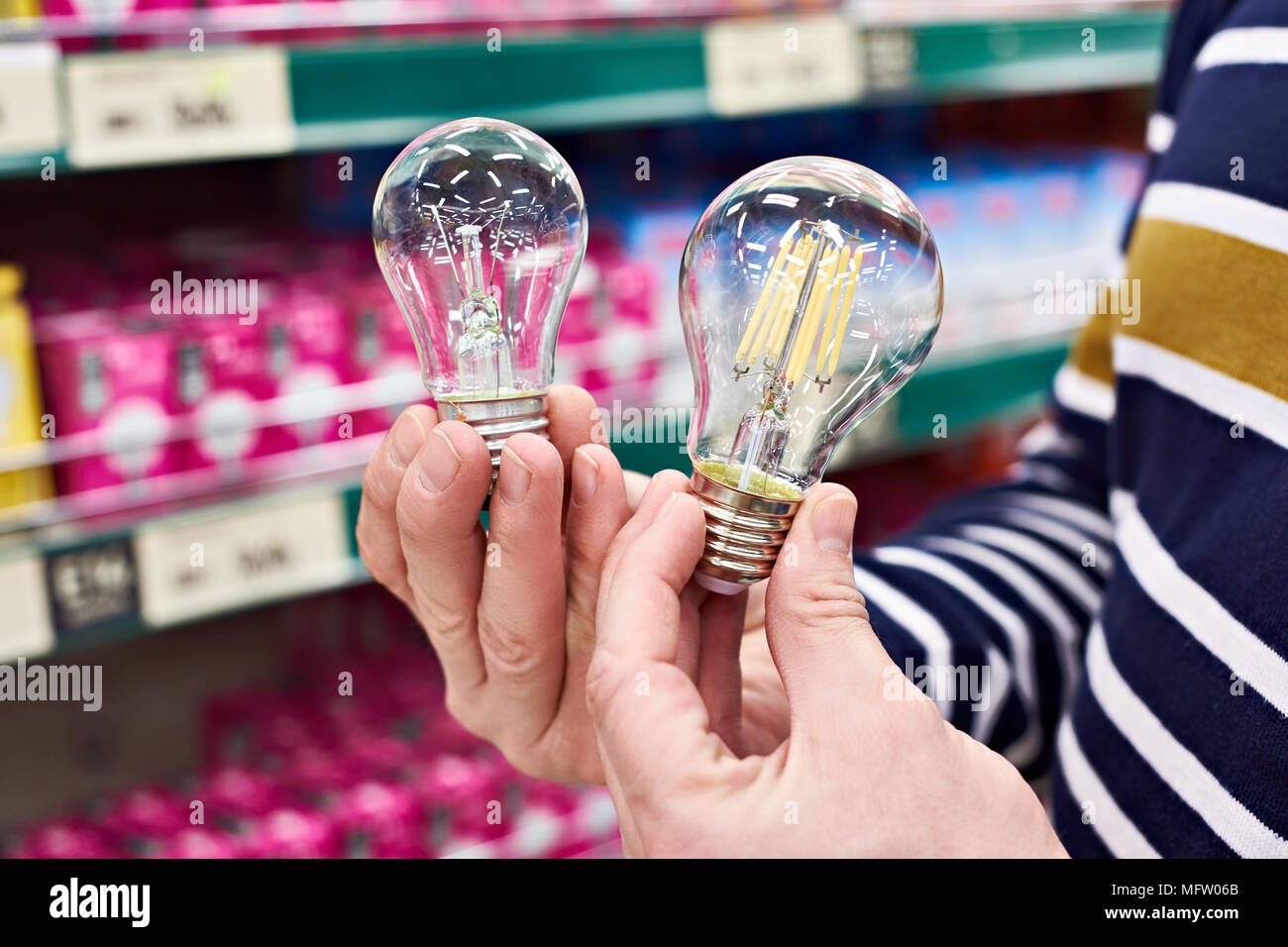 LED und Glühlampen in den Händen der Käufer im Store. Stockfoto