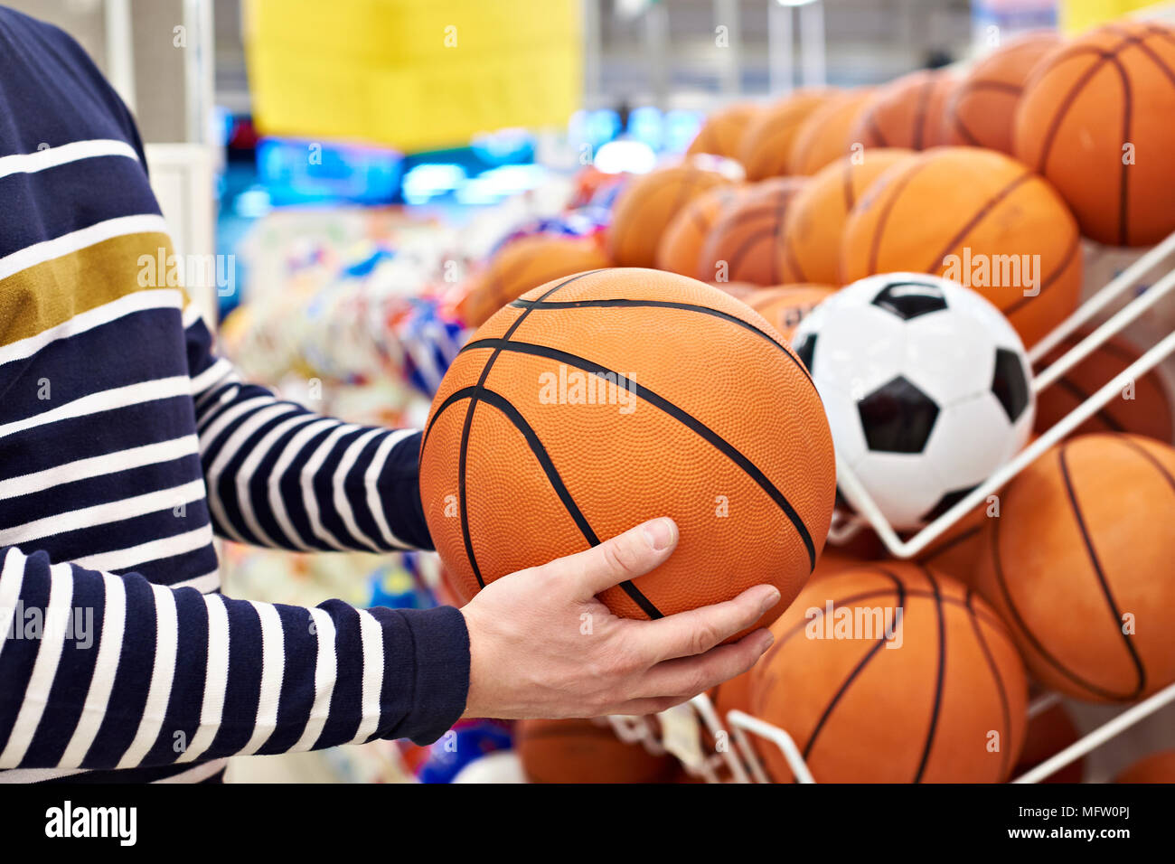 Buyer's Hände mit Fußball und Basketball in der Sport Shop Stockfoto