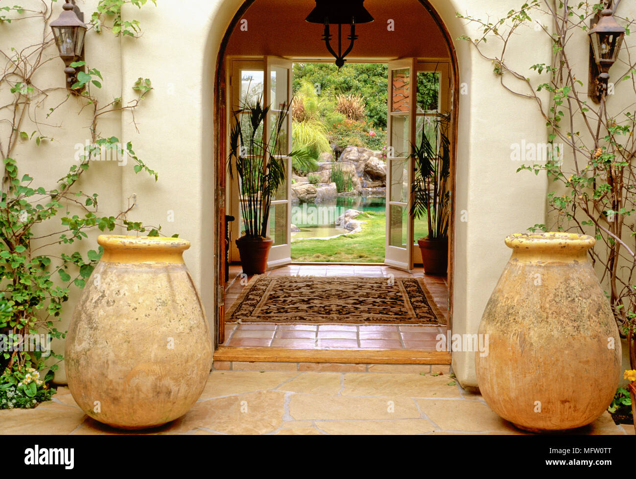 Große Vasen Grenze einen Eingang mit Garten Teich über Stockfoto
