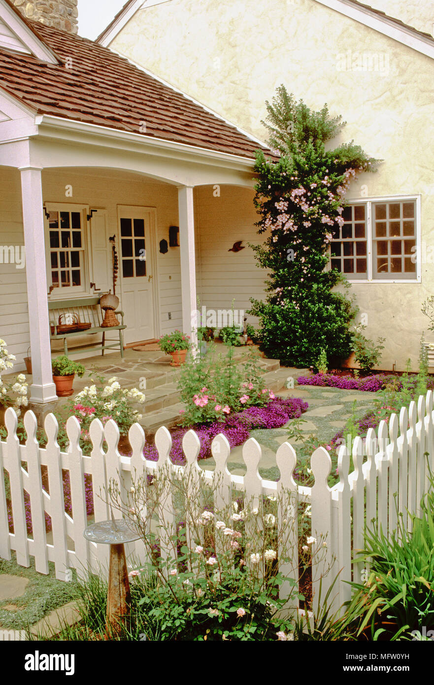 Lobelia und Rosa gepflanzt im umzäunten Garten von country style house Stockfoto