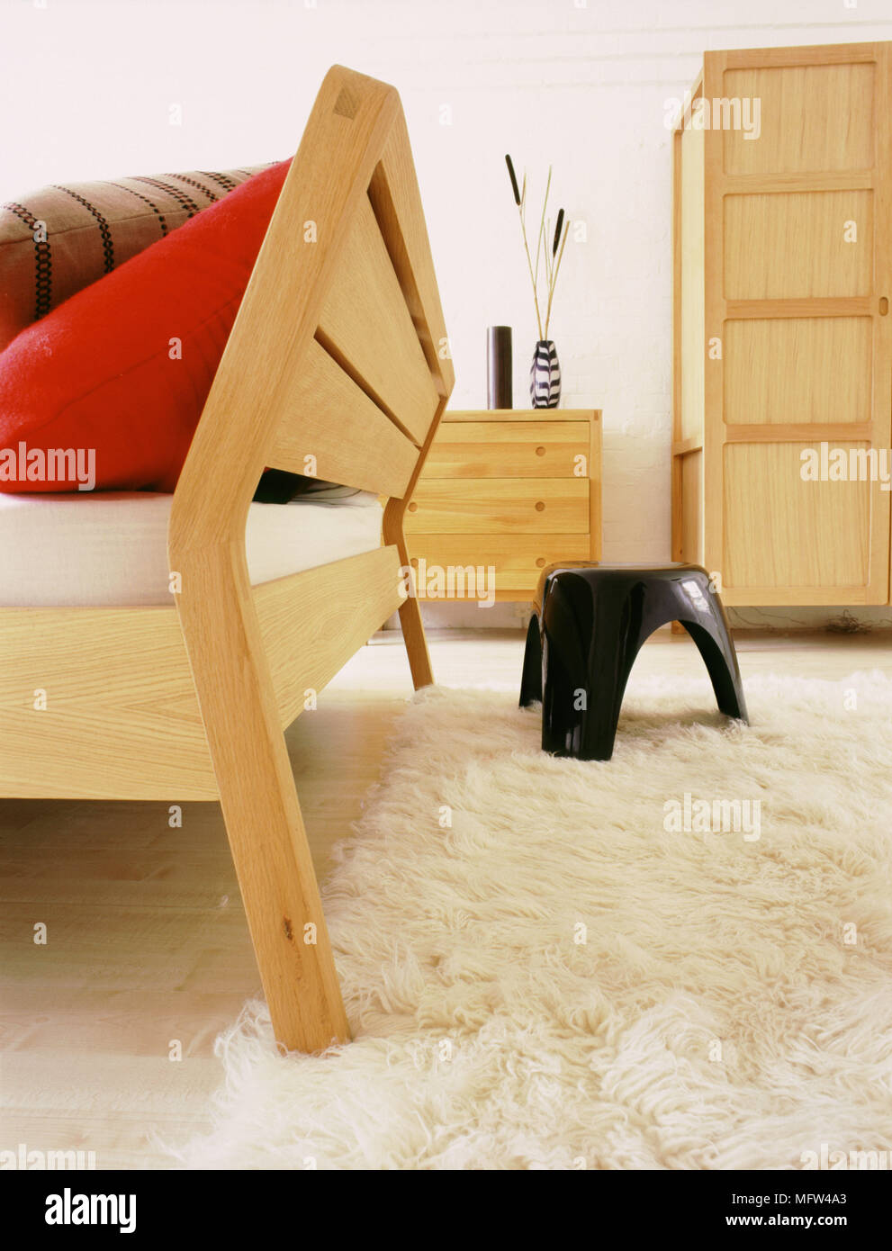 Ein Detail einer modernen neutralen Schlafzimmer Holz Doppelbett Kommode kleiderschrank Langer Flor Wolldecke Kunststoffhocker Stockfoto