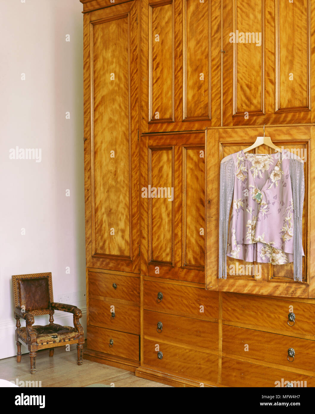 Detail der Kleidung hängt an der Tür eines großen Kleiderschrank aus Holz. Stockfoto