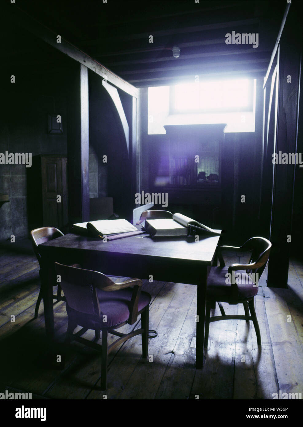 Rustikalen Speisesaal Holz Tisch Stühle Innenräume Zimmer stimmungsvolles Licht Schatten Moody Stockfoto