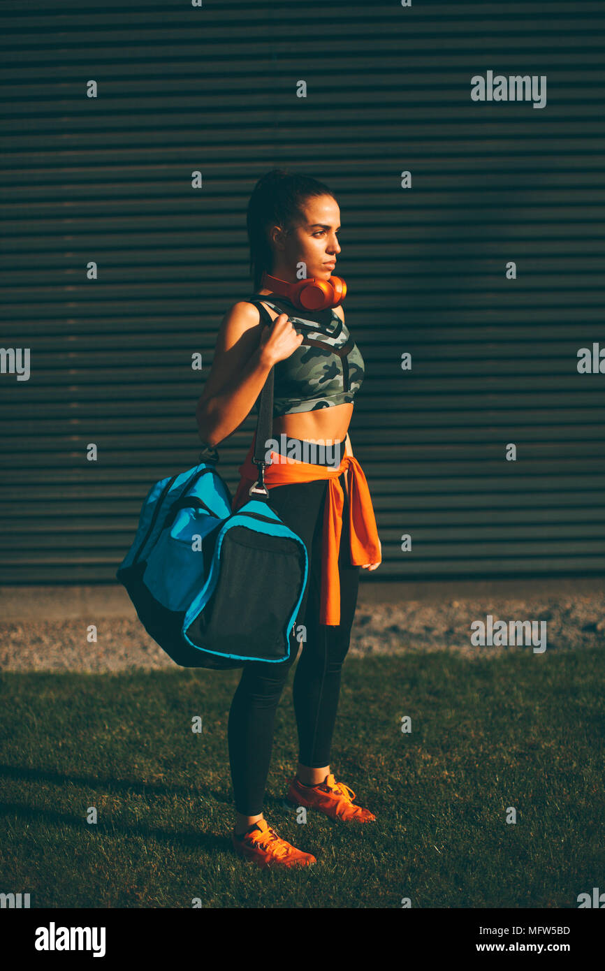 Junge Frau, die mit Sport bag Outdoor nach dem Training Stockfoto