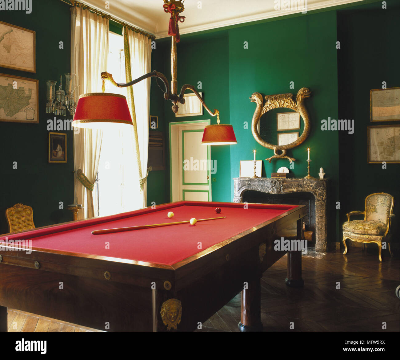 Eine traditionelle grüne Spiele Zimmer eine rote Snookertisch Deckenlicht, Kamin Zeitraum vergoldeten Stuhl Stockfoto