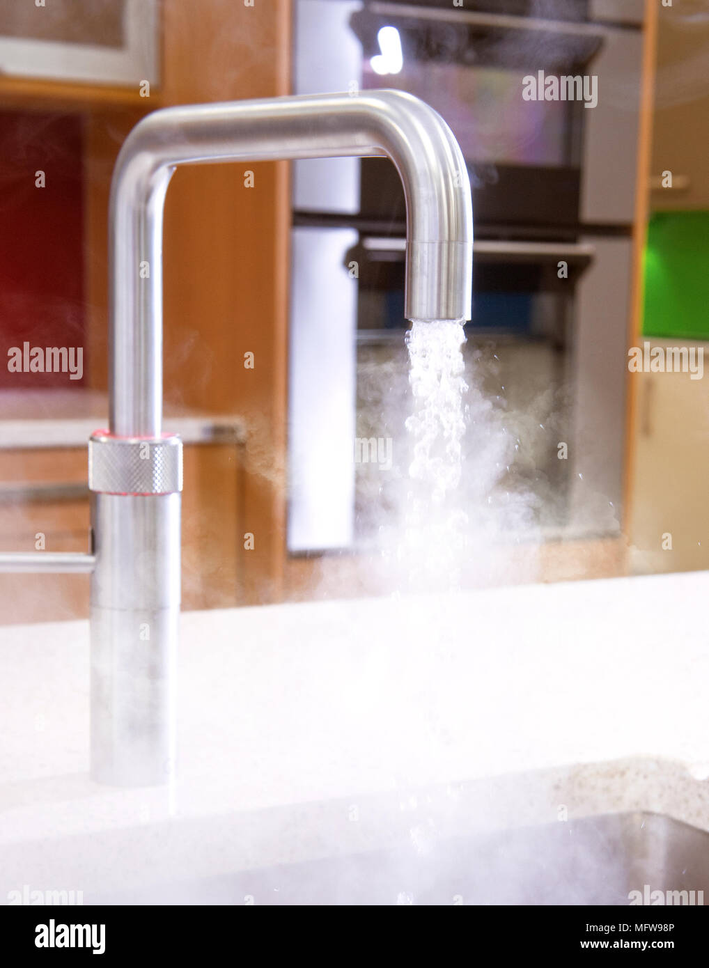 Eine sofortige heißes Leitungswasser mit dampfenden Wasser in ein Spülbecken. Stockfoto