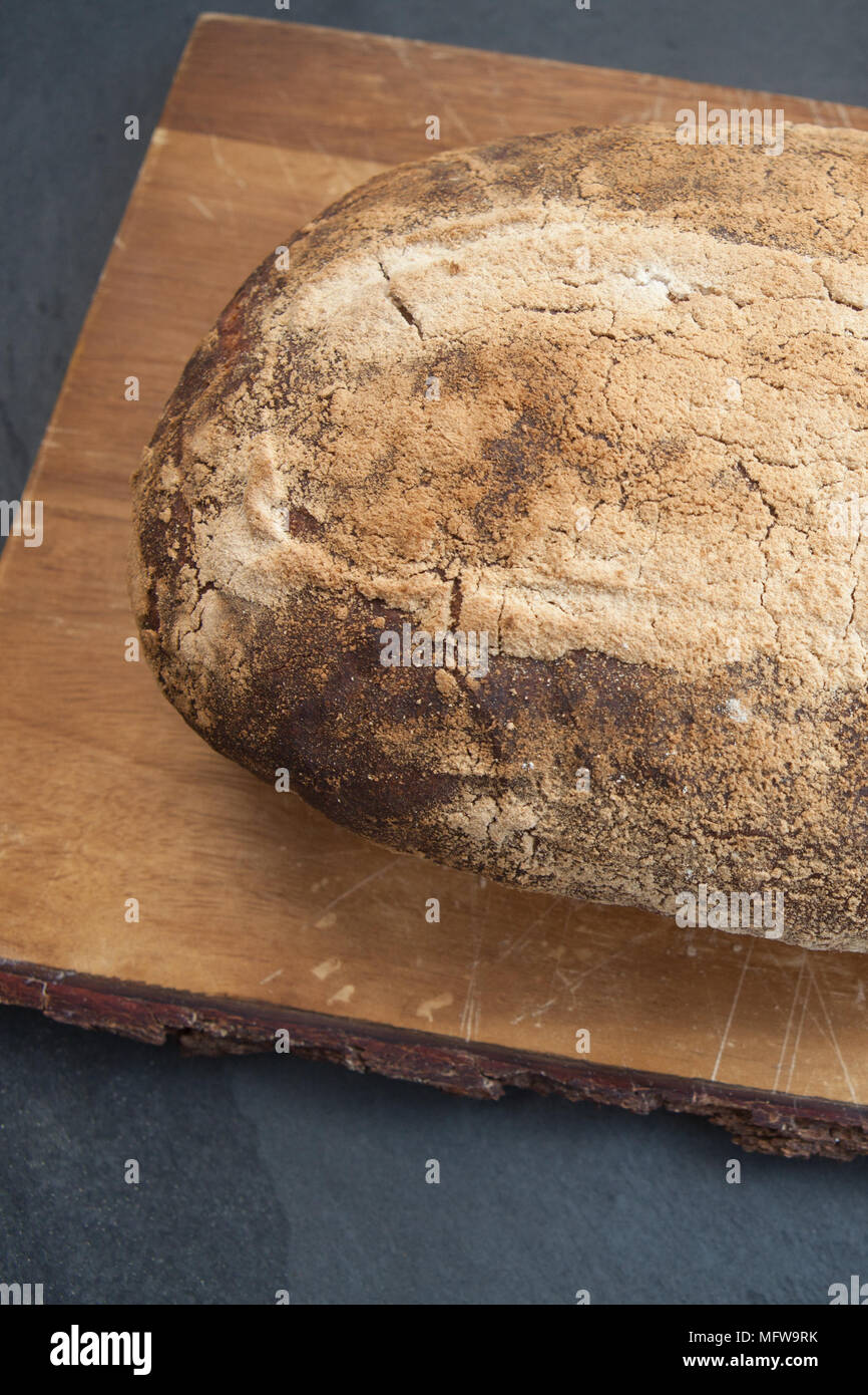 Selbst gebackenes crusty Sauerteigbrot, mit weissen und Gemälzt Mehl auf ein Brett Stockfoto