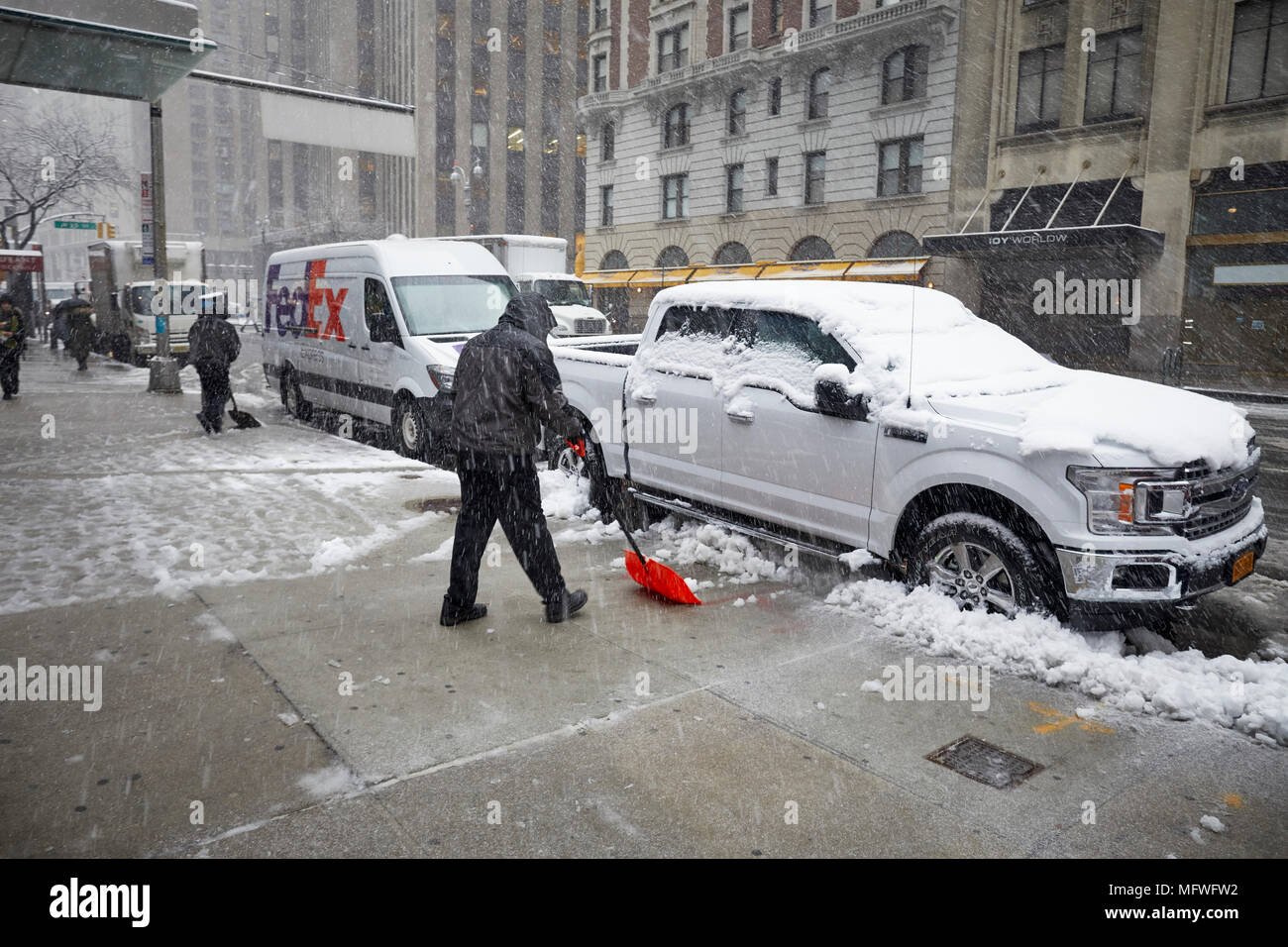 Manhattan in New York City, Büroangestellter clearing Schnee vom Bürgersteig in der Nähe von Times Square Broadway Stockfoto