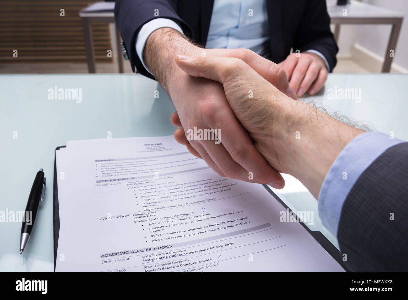 Unternehmer und Bewerber zitternden Hand mit Resume auf Schreibtisch Stockfoto