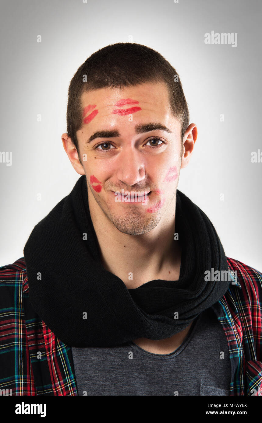 Porträt des jungen Mannes mit Gesicht voller Lippenstift Marken Küsse Stockfoto