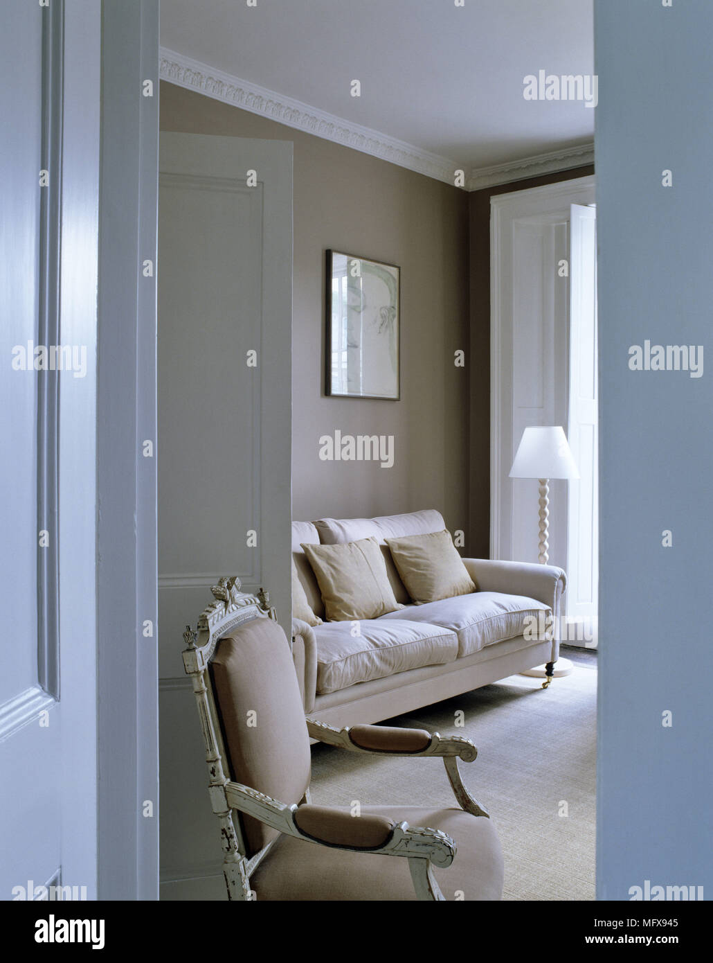Blick durch die offene Tür zu den gepolsterten Sofa und Stil der Zeit Stuhl Stockfoto