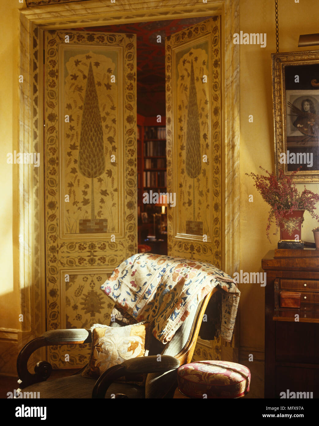 Sessel vor dekorativ bemalte teilweise offene Türen Stockfoto