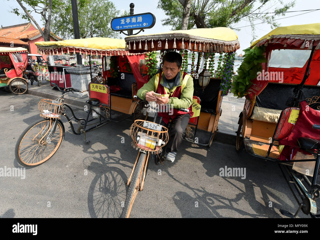 (180427) - ZHENGZHOU, April 27, 2018 (Xinhua) - Xu Shijie, einem Pedicab Driver, wartet auf Kunden in Kaifeng, China Provinz Henan, 26. April 2018. 51-jährige Xu Shijie, oder Jason in englischer Sprache, ist eine Fahrradrikscha Treiber. Wie viele pedicab Treiber können nicht sprechen Englisch, Xu, die Englische Bücher in seiner Freizeit lesen liebt, steht heraus. Da Xu seine erste ausländische Kunden im Jahr 2003 traf, er hat sich entschlossen, sein Englisch hören und sprechen zu verbessern. Xu praktiziert Englisch jeden Tag und jetzt kann er führt der Kaifeng Geschichte, Sehenswürdigkeiten und Brauchtum in Englisch fließend. Auch hilft er h Stockfoto