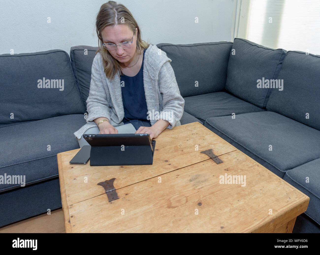 Eine Frau mittleren Alters zu Hause mit ihren Laptop Stockfoto