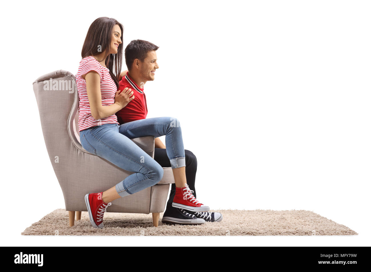 Junges Paar sitzt in einem Sessel und lächelnd auf weißem Hintergrund Stockfoto