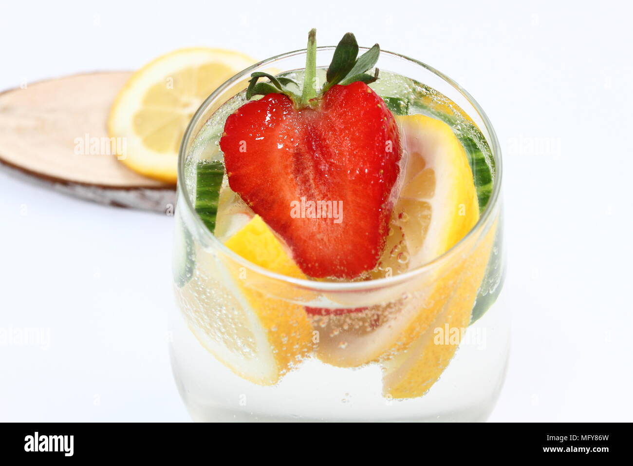 Detox aromatisiertes Wasser mit Zitrone, Gurke und Erdbeere auf weißem Hintergrund mit Dekoration. Gesunde Ernährung Konzept. Erfrischende Sommer cocktail Stockfoto