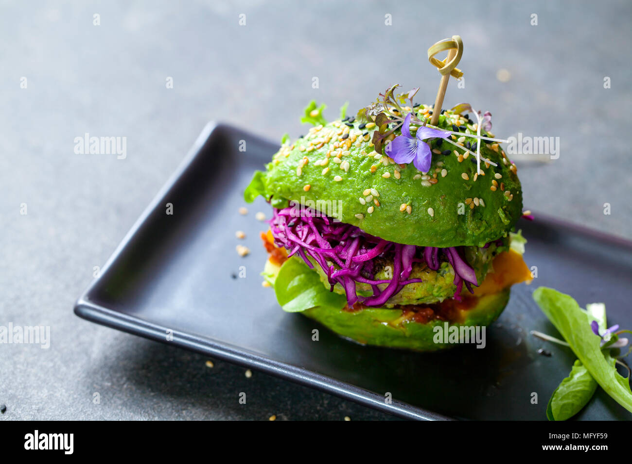 Avocado Sandwich mit Grüne vegane Burger, gebratene gelbe Paprika und eingelegtes Rotkohl Stockfoto