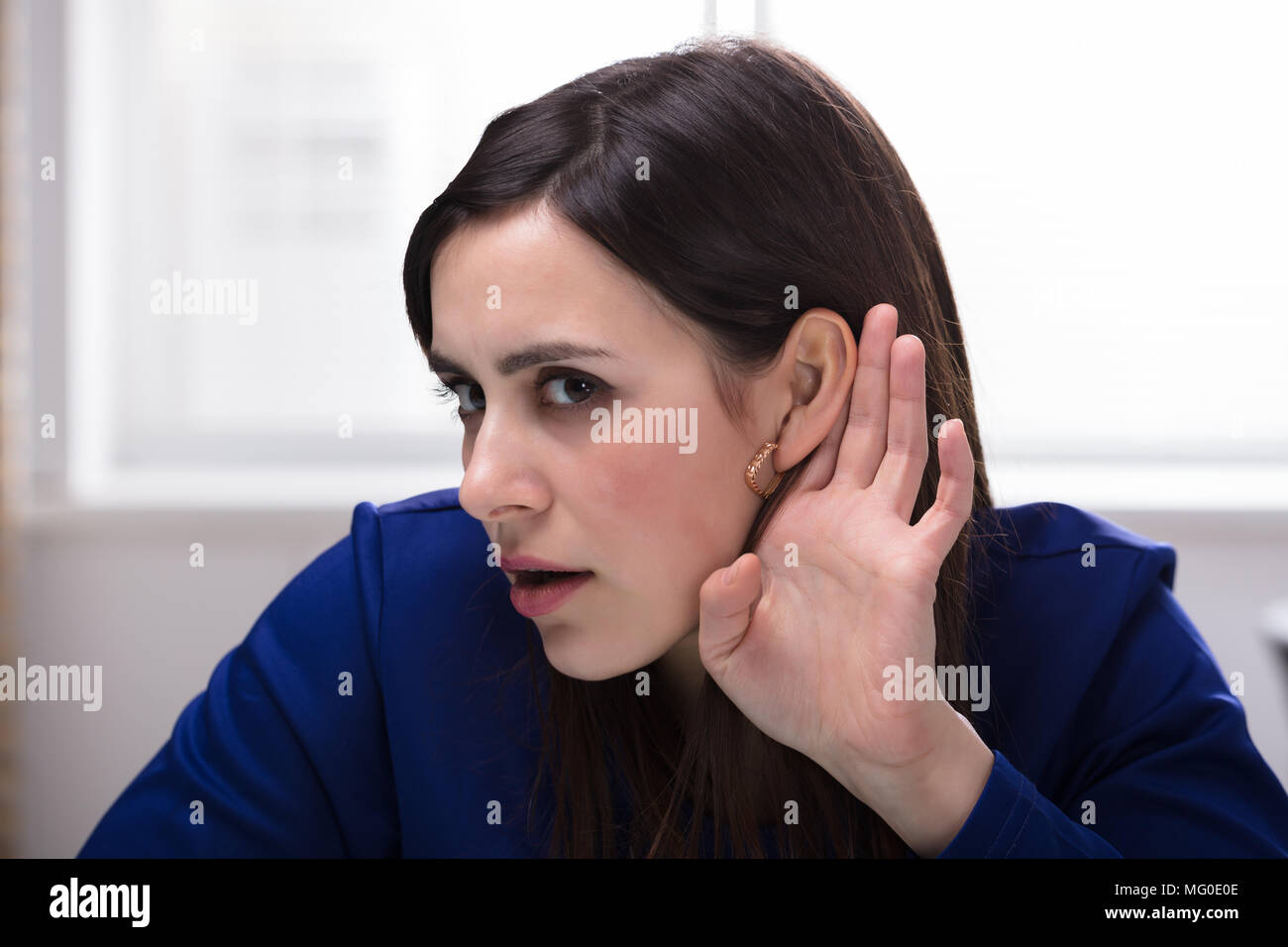 Nahaufnahme einer jungen Unternehmerin Versuchen zu Hören, mit der Hand über das Ohr Stockfoto Nahaufnahme einer jungen Unternehmerin Versuchen zu Hören, mit der Hand über das Ohr Stockfoto