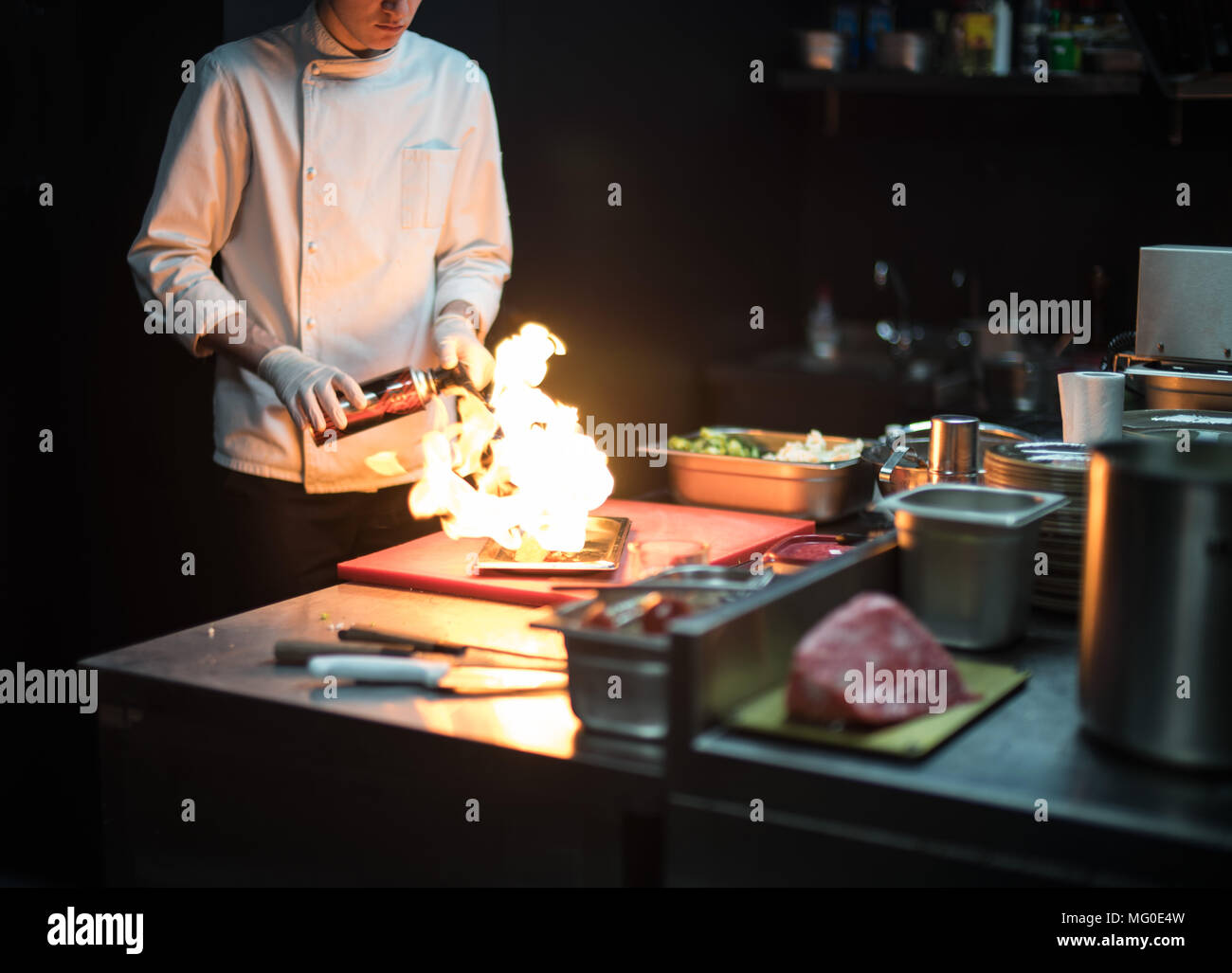 Restaurant Küchenchef Vorbereitung Lachsfilet flambiert. Stockfoto