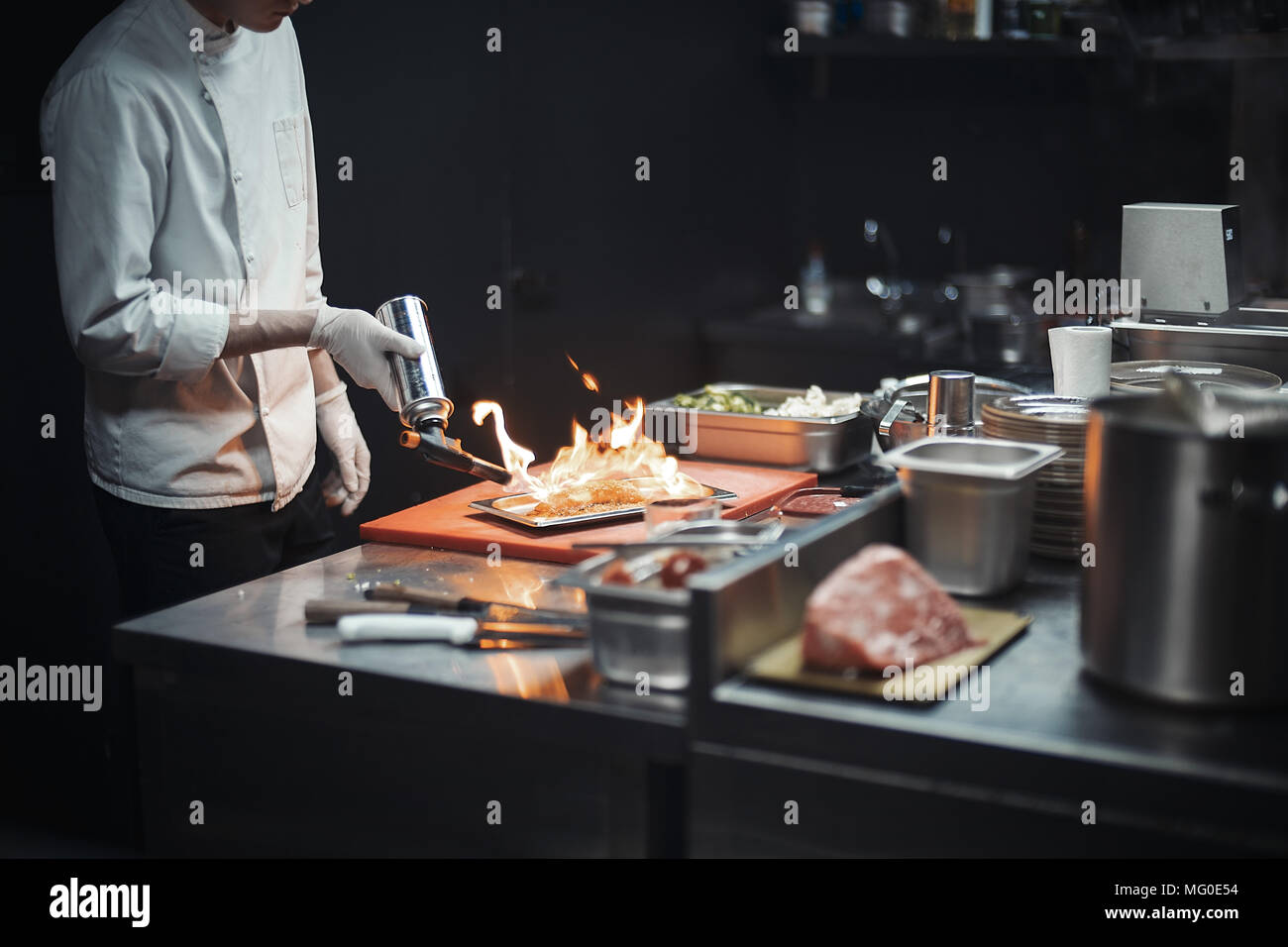 Restaurant Küchenchef Vorbereitung Lachsfilet flambiert. Stockfoto