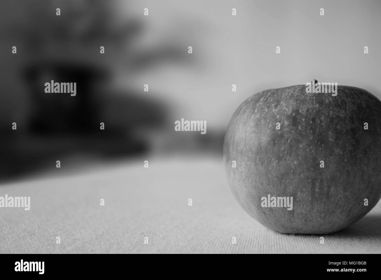 Nahaufnahme von einem roten Apfel mit unscharfen Hintergrund in Schwarz und Weiß. Stockfoto