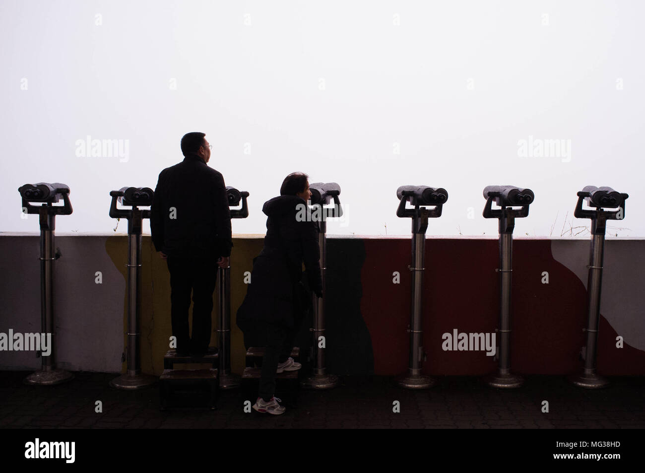 Touristen stehen und schauen in Richtung Nordkorea während eines Schneesturmes bei Dorasan innerhalb der entmilitarisierten Zone zwischen Nord- und Südkorea. Stockfoto