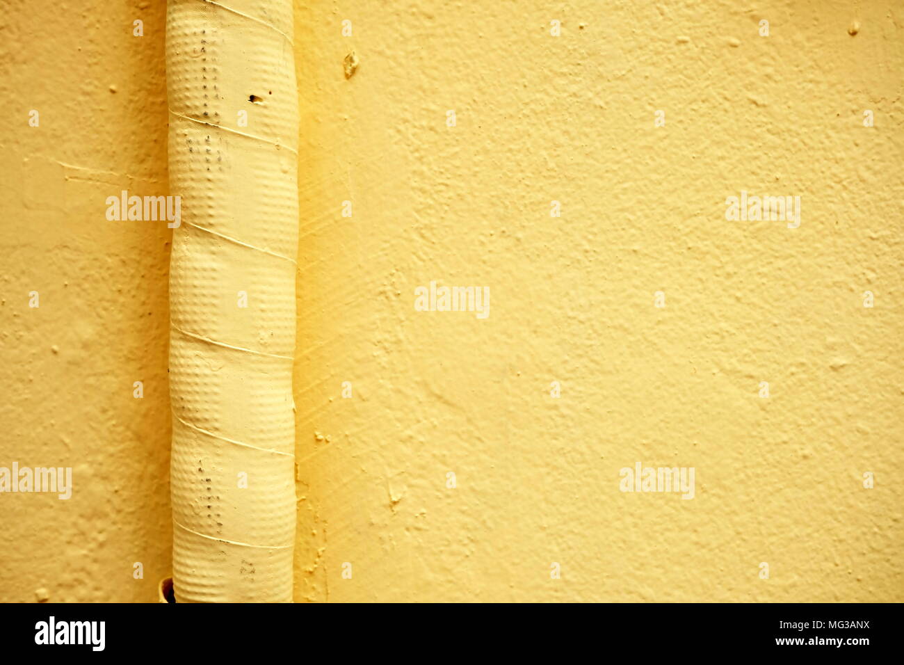 Luftleitung auf gelbe Farbe Betonwand. Stockfoto