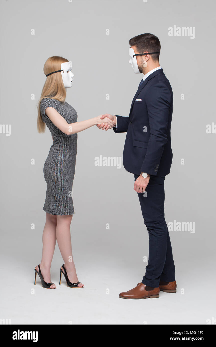 Junge anonymer Geschäftsleute in Maske Handshake auf grauem Hintergrund Stockfoto