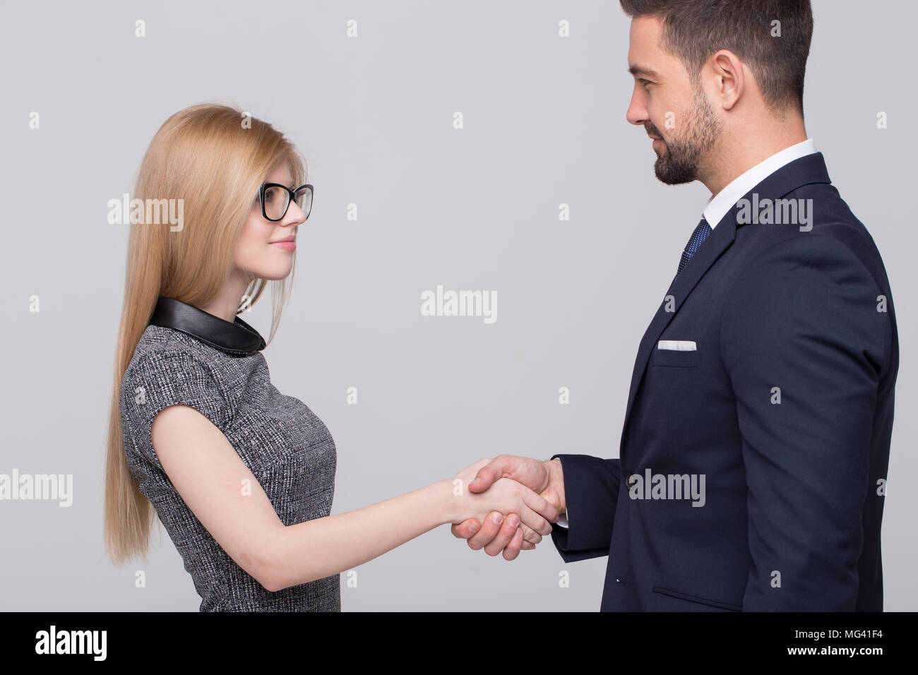 Young Professional kaukasischen Geschäftsleute Handshake auf grauem Hintergrund Stockfoto