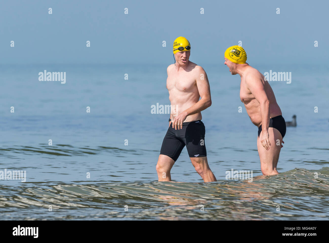 Ein Paar der männlichen Schwimmer das Tragen von Badekappen und Kurzschlüsse in den See an einem heißen Tag in Brighton, East Sussex, England, UK. Stockfoto
