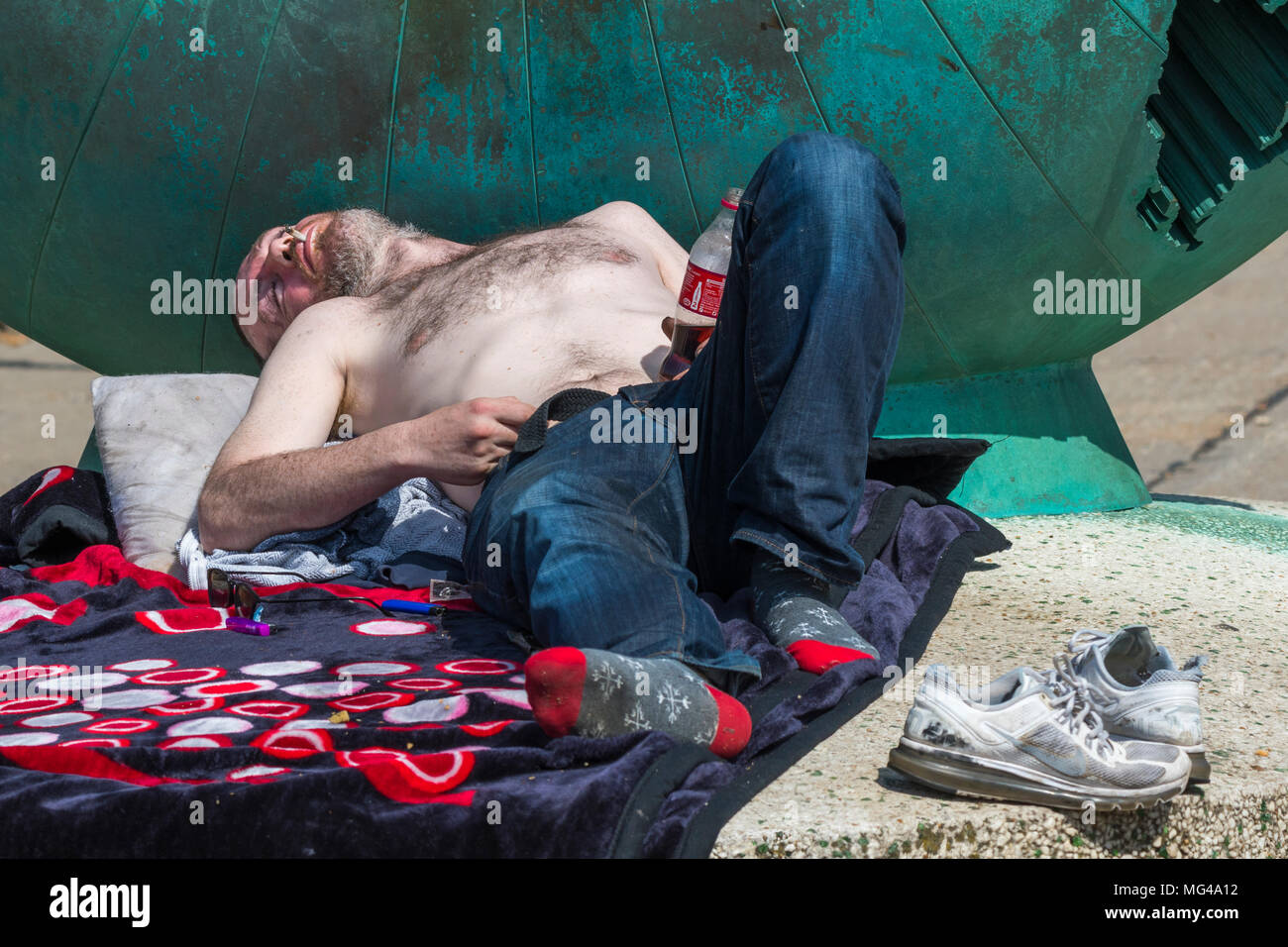 Mann erscheinen, heimatlos zu sein und Schlafen in Brighton, East Sussex, England, UK. Obdachlosigkeit in Großbritannien. Auf Glück. Stockfoto