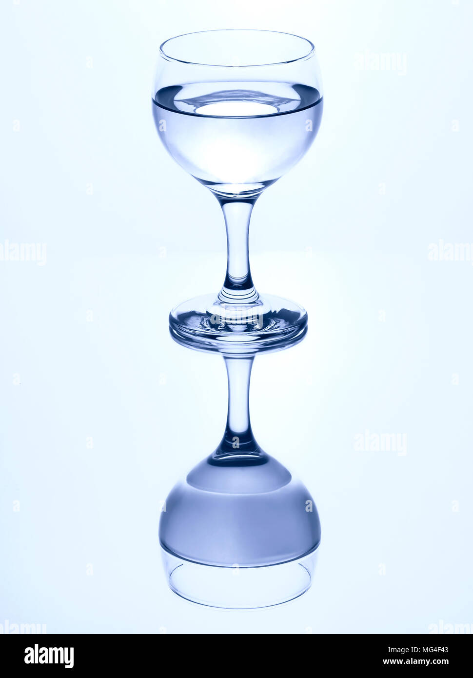 Single stammte Glas Wasser auf einen weißen Hintergrund mit Spiegelbild isoliert. Stockfoto
