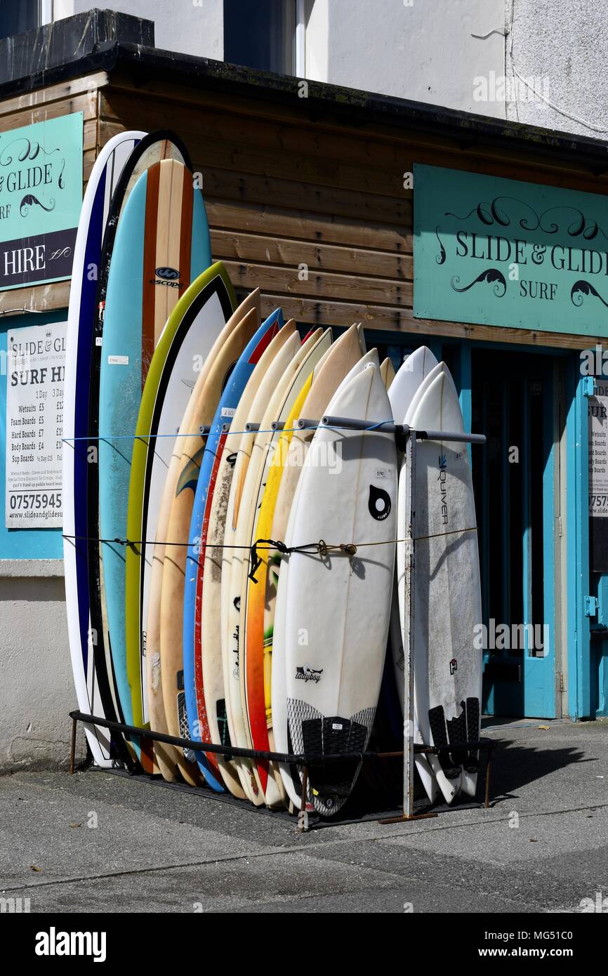 Surfbretter aufgereiht außerhalb ein Shop in Newquay in Cornwall. Stockfoto