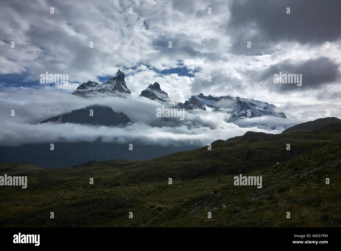 Cerro Paine Grande und Berge inmitten der Wolken. Panorama. Weite Einstellung. Stockfoto